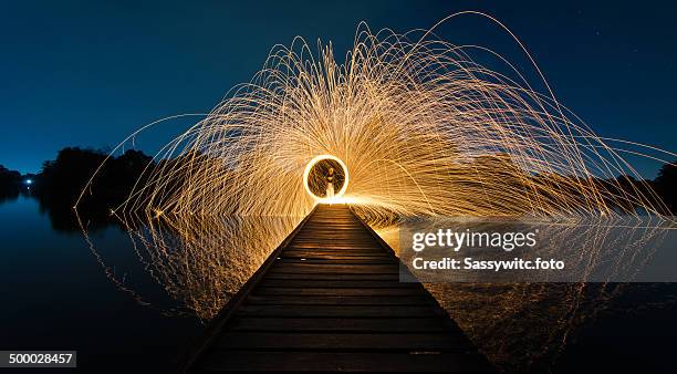 burning steel wool fireworks on wooden bridge. - light painting stock pictures, royalty-free photos & images