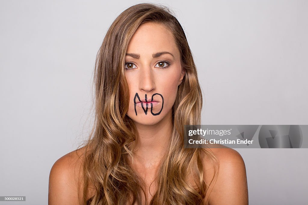 Woman with writing "No" on her lips