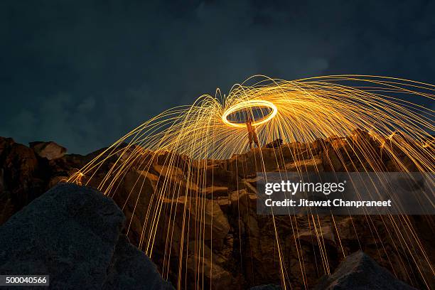abstract background from spinning steel wool on cliff at night time - 橈骨 ストックフォトと画像