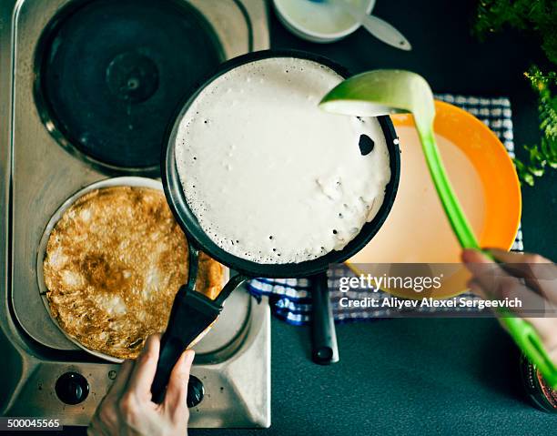 woman making pancakes in kitchen - crepes stock-fotos und bilder