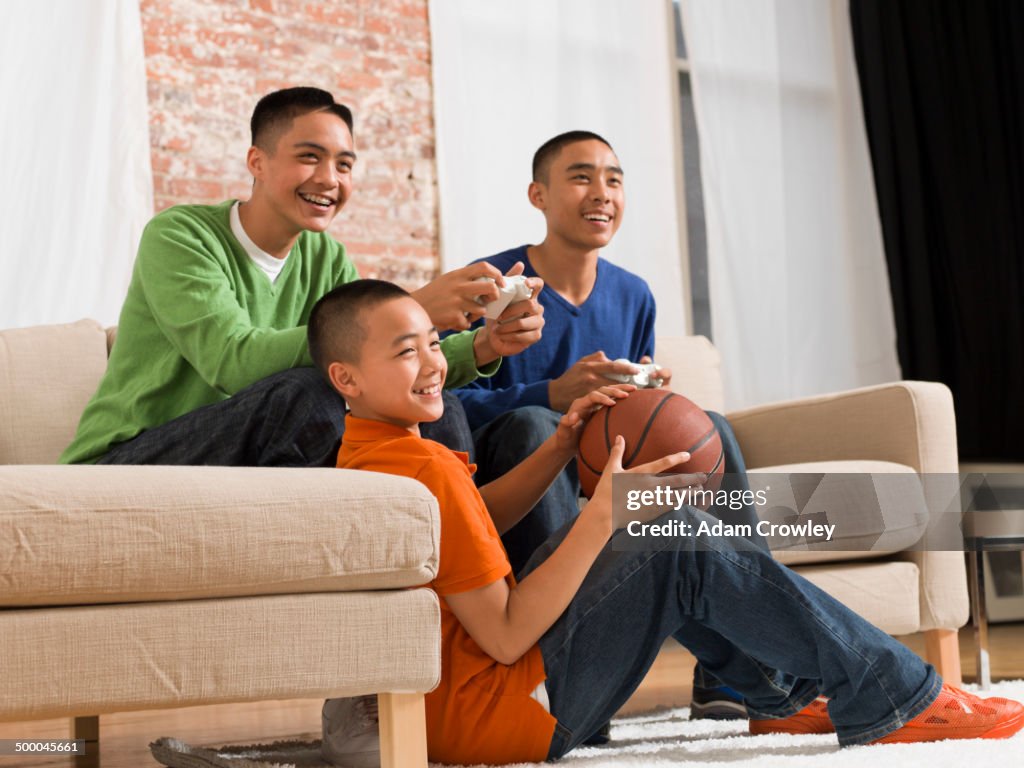 Mixed race brothers playing video games together