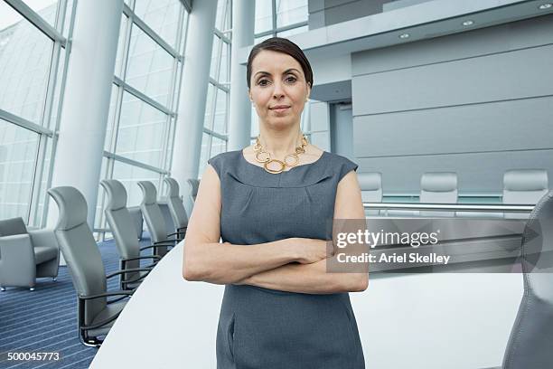 hispanic businesswoman standing in conference room - corporate business owner stock pictures, royalty-free photos & images