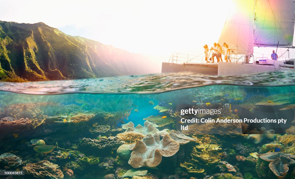 Friends diving off boat into tropical reef