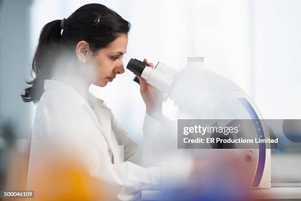 pakistani scientist using microscope in lab - arabic doctor stockfoto's en -beelden