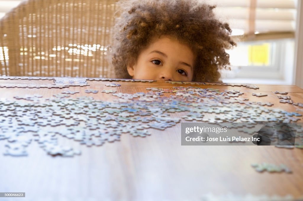 Mixed race boy doing jigsaw puzzle