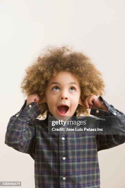 mixed race boy making a face - pulling ear stock pictures, royalty-free photos & images