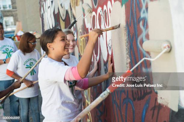 volunteers painting over graffiti wall - 12 12 12 2013 film stock-fotos und bilder