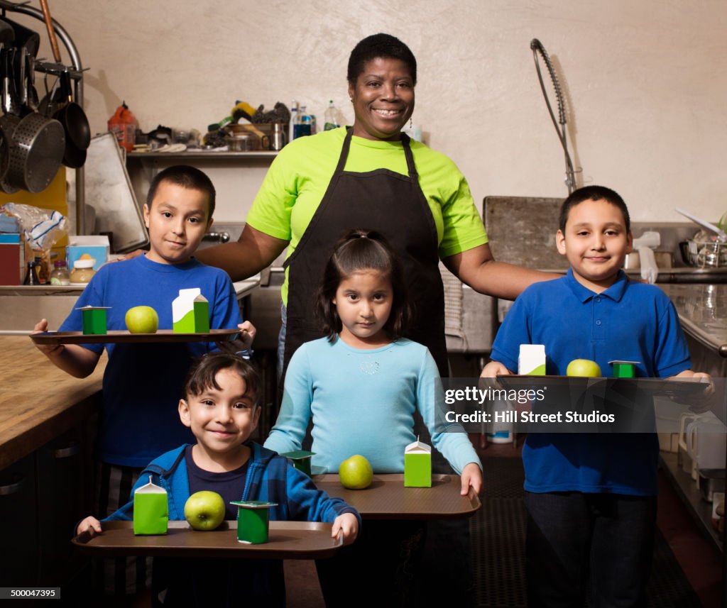 Chef standing with students in school cafeteria kitchen