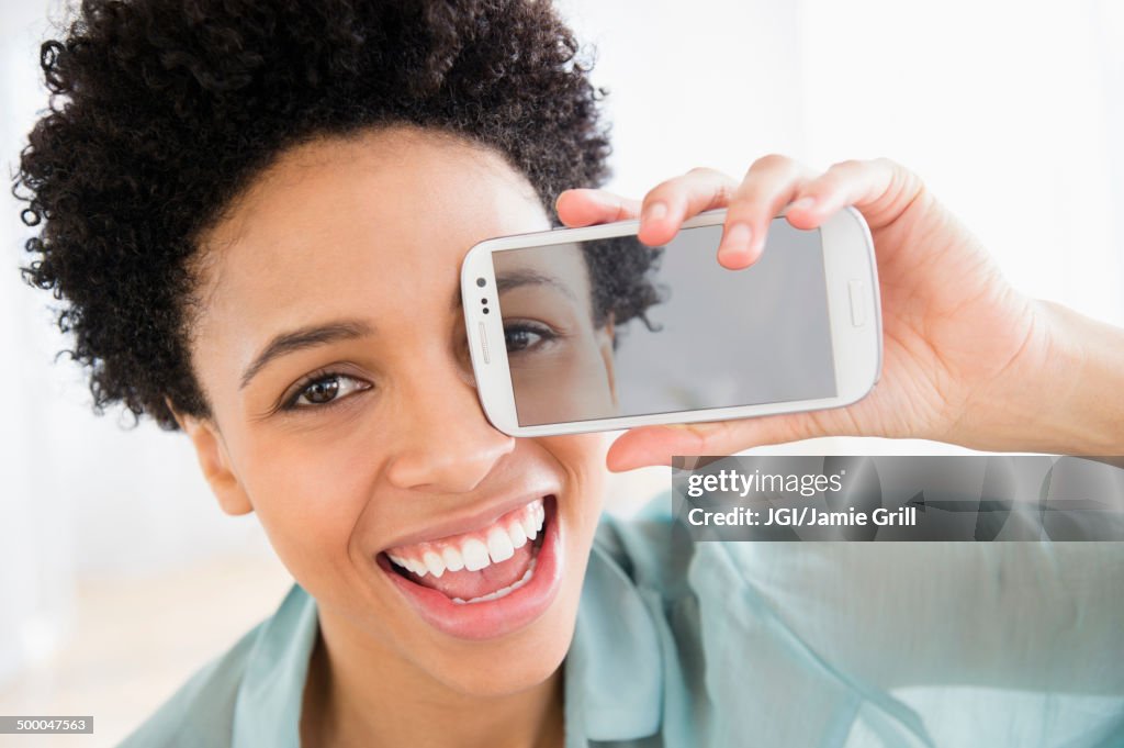 Black woman holding photo of her eye over her face