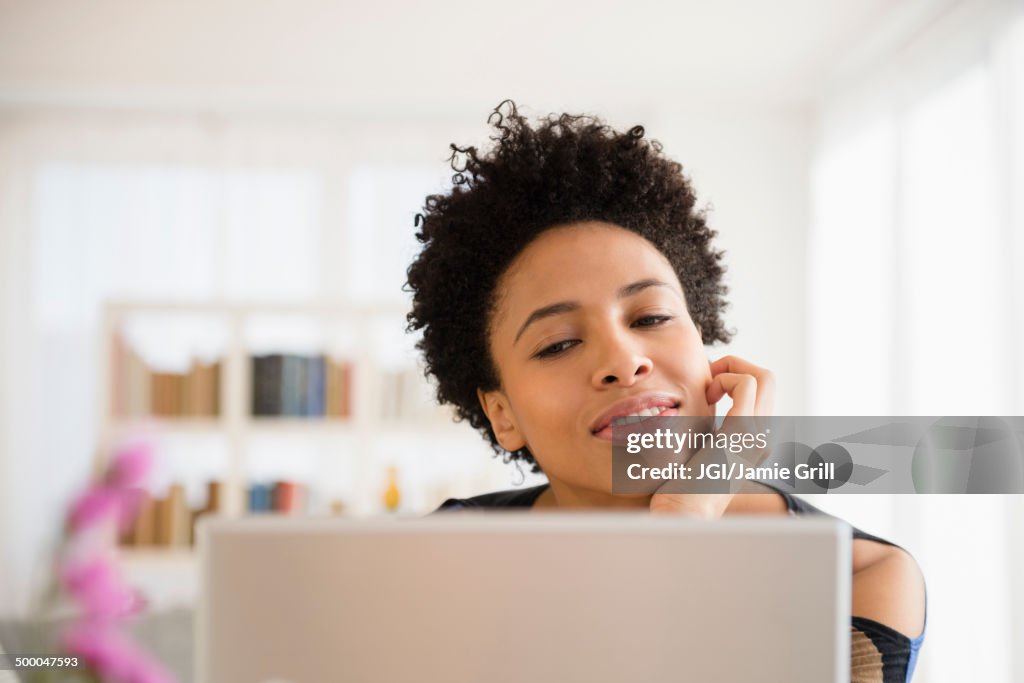 Black woman using laptop at table