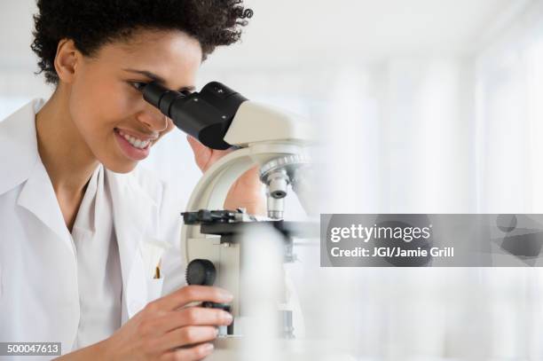 black scientist using microscope in lab - lab closeups stock-fotos und bilder