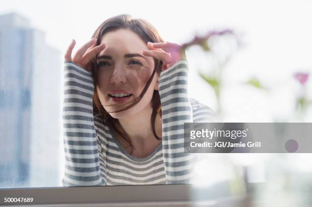 woman peering in through window - neugierde stock-fotos und bilder