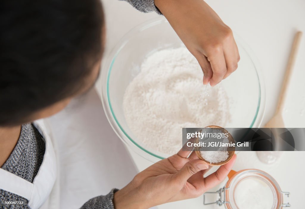 Mixed race woman baking in kitchen