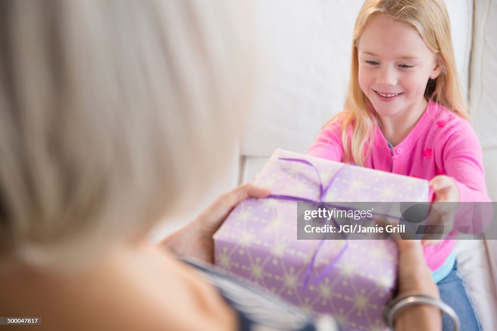 Senior Caucasian woman giving granddaughter present