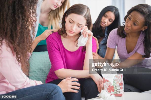 crying woman surrounded by friends - friendship breakup stock pictures, royalty-free photos & images