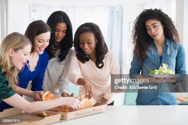 woman with salad watching friends eat pizza - envy stock pictures, royalty-free photos & images