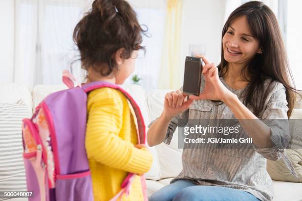 hispanic mother taking picture of daughter ready for school - day one stock pictures, royalty-free photos & images