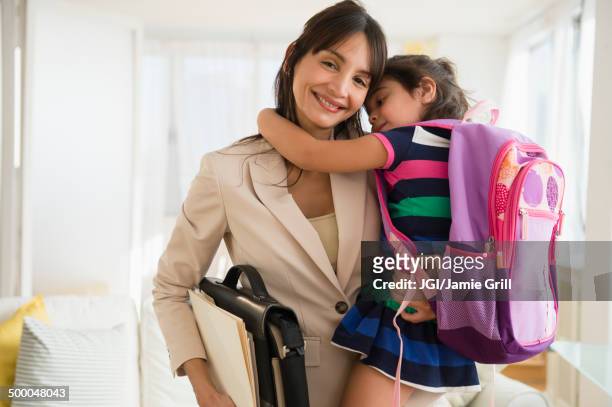 hispanic daughter hugging mother as she leaves for work - routine work stock pictures, royalty-free photos & images