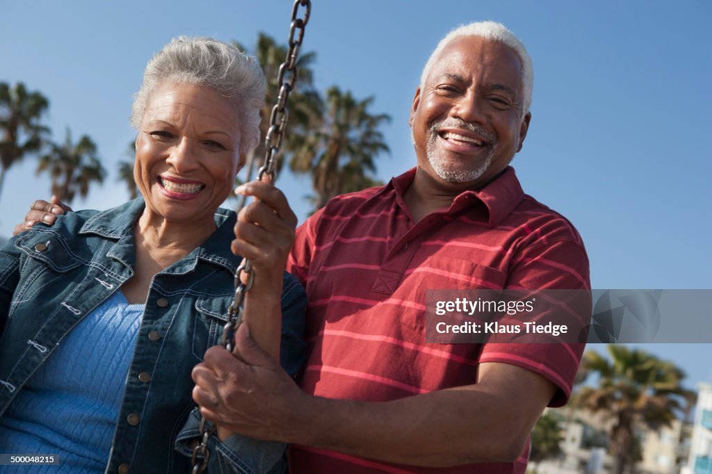 Senior African American couple on swing set