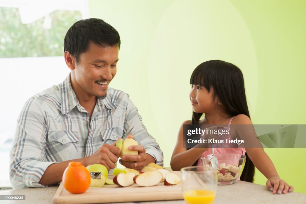 Asian father and daughter having breakfast together