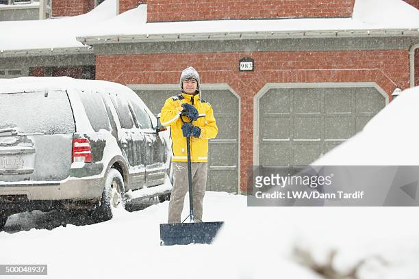 caucasian boy shoveling driveway in snow - shoveling driveway stock pictures, royalty-free photos & images