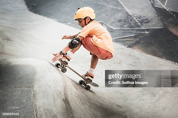 mixed race boy riding skateboard in skate park - skating helmet stock pictures, royalty-free photos & images