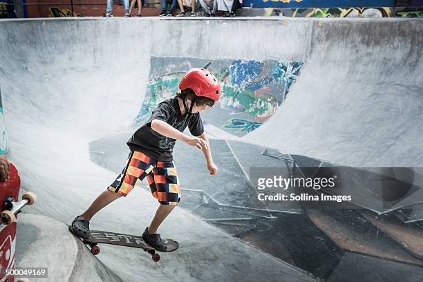 caucasian boy riding skateboard in skate park - boy skatepark stock-fotos und bilder