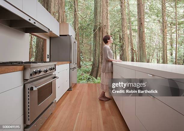 woman standing in kitchen in forest - barefoot floor stock pictures, royalty-free photos & images