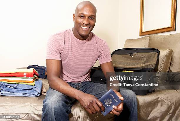 black man packing passport for trip - portraits of people passport fotografías e imágenes de stock