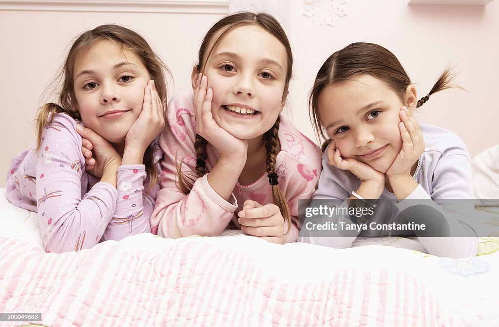 Mixed race girls laying on bed