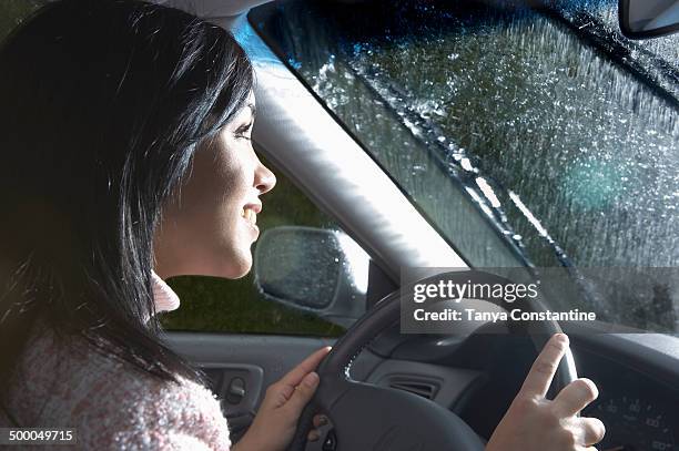 indian woman driving in heavy rain - asian girl driving stock pictures, royalty-free photos & images
