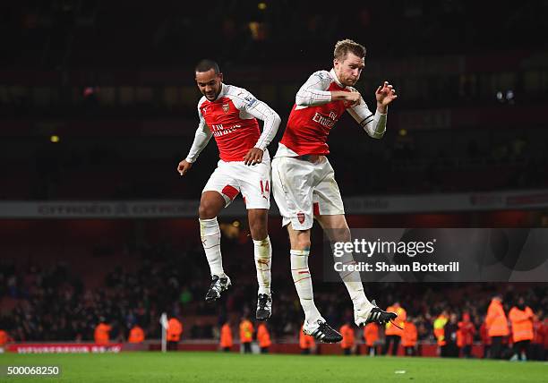 Theo Walcott and Per Mertesacker of Arsenal celebrate their team's 3-1 win in the Barclays Premier League match between Arsenal and Sunderland at...