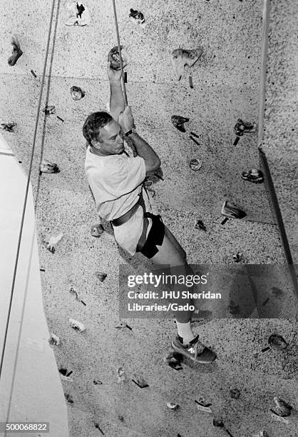 Michael Rubens Bloomberg, candid shot, Bloomberg is climbing a climbing wall and dangling from the safety harness, ca 47 years of age, 1997. .