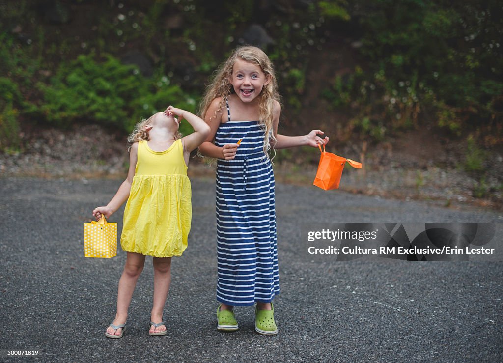 Portrait of two young sisters enjoying confectionary gift bags
