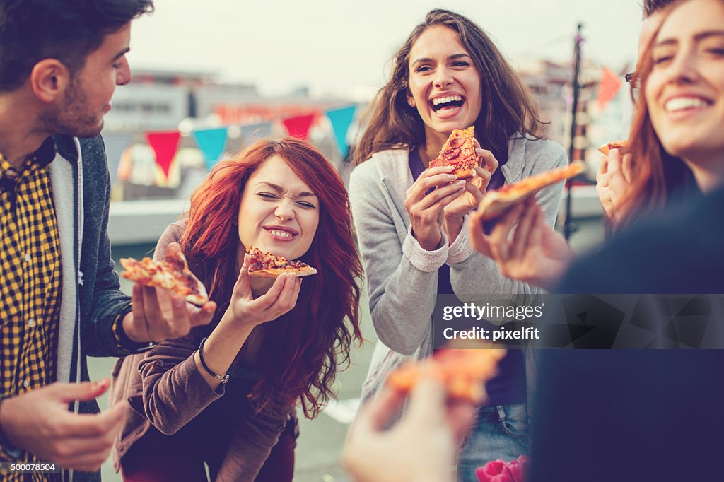 Young people eating pizza at party