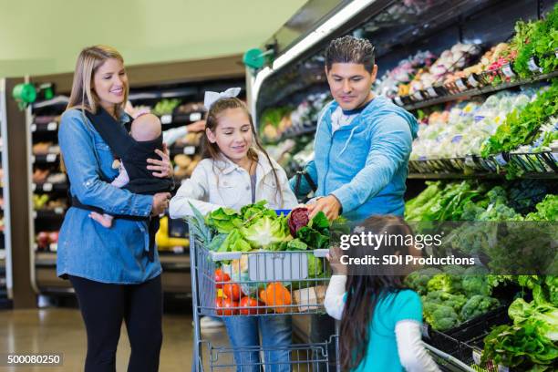 large family shopping for groceries together in supermaket - sportswear retail stock pictures, royalty-free photos & images