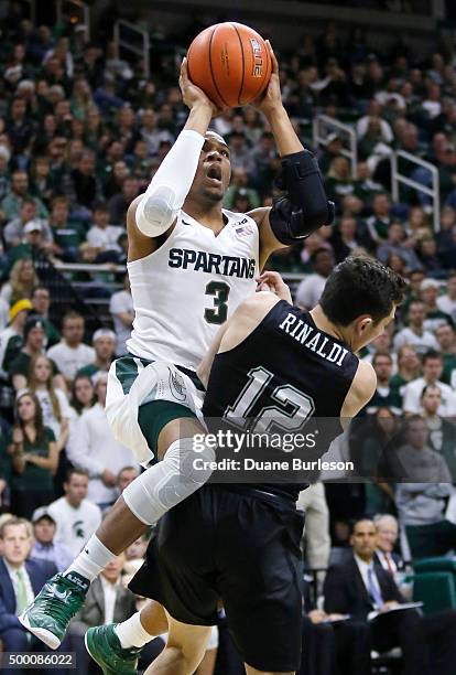 Alvin Ellis III of the Michigan State Spartans collides with John Rinaldi of the Binghamton Bearcats while taking a shot during the second half at...