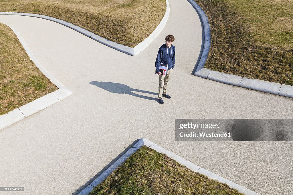 Germany, Baden-Wurttemberg, Teenage boy standing at crossing