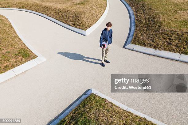 germany, baden-wurttemberg, teenage boy standing at crossing - choix photos et images de collection