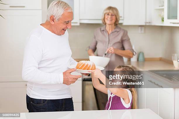 senior couple with granddaughter in kitchen - plate side view stock pictures, royalty-free photos & images