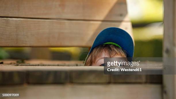 little boy hiding at playground - spähen stock-fotos und bilder
