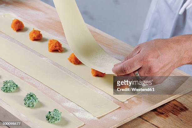 producing homemade tortelloni with apinach ricotta and pumpkin filling - tortelloni stock-fotos und bilder