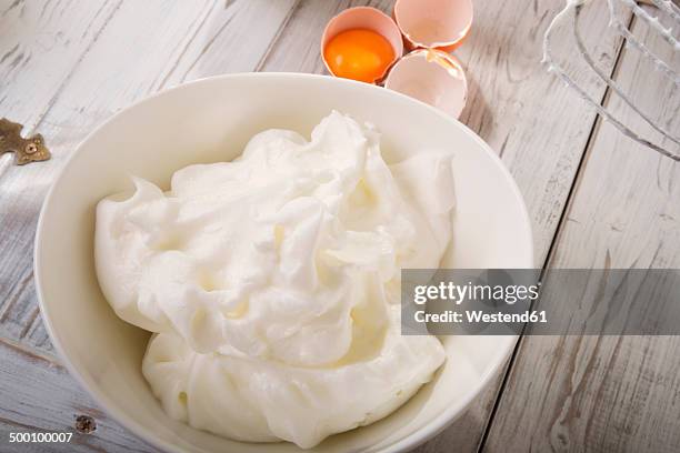 bowl of beaten egg white on wooden table - whipped food stock pictures, royalty-free photos & images