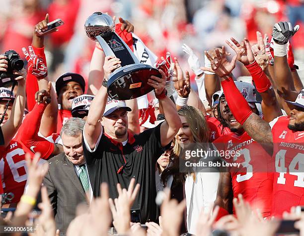 Head coach Tom Herman of the Houston Cougars raises the AAC Championship Trophy after defeating the Temple Owls at TDECU Stadium on December 5, 2015...