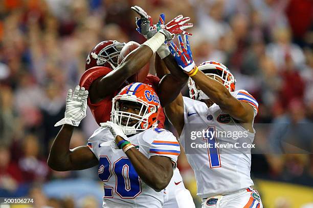 Wide receiver Calvin Ridley of the Alabama Crimson Tide receives the ball over defensive back Marcus Maye of the Florida Gators and defensive back...