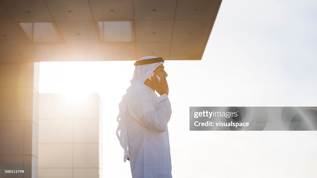 Emirati Businessman On A Rooftop In Evening Sunlight