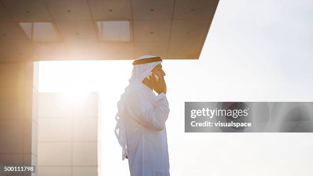 emirati businessman on a rooftop in evening sunlight - arab businessman stock pictures, royalty-free photos & images