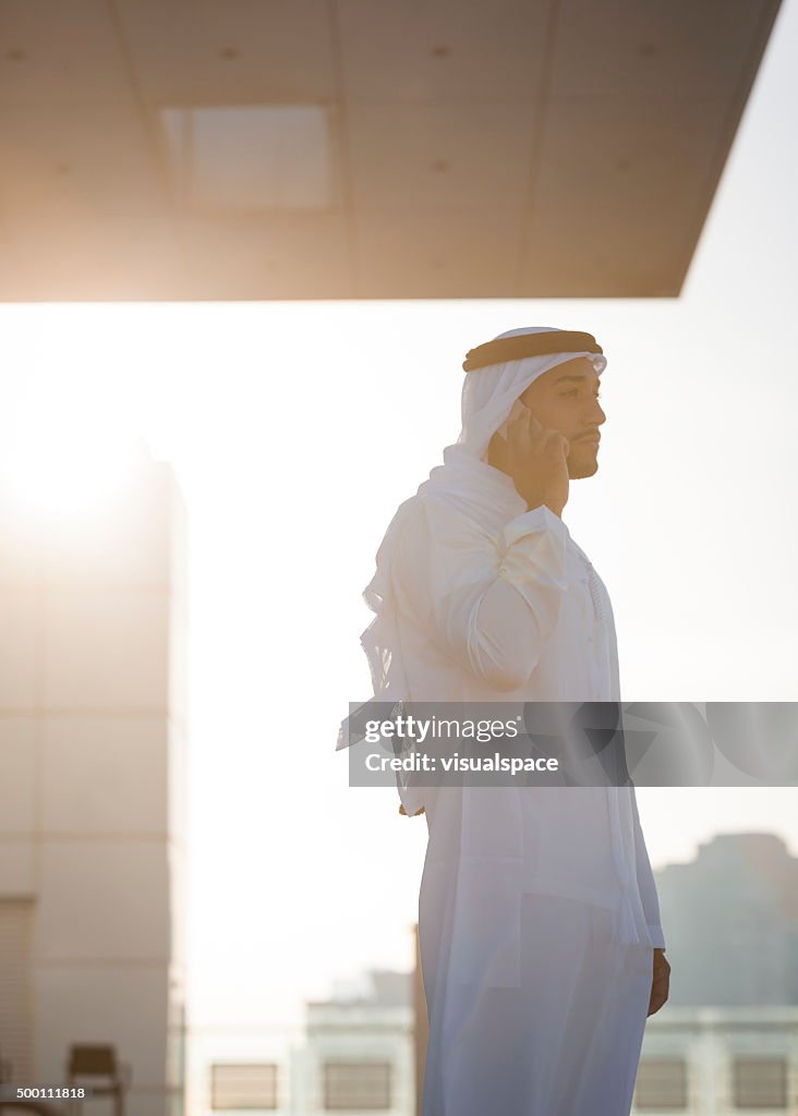 Arab Businessman On The Phone On A Skyscraper's Rooftop