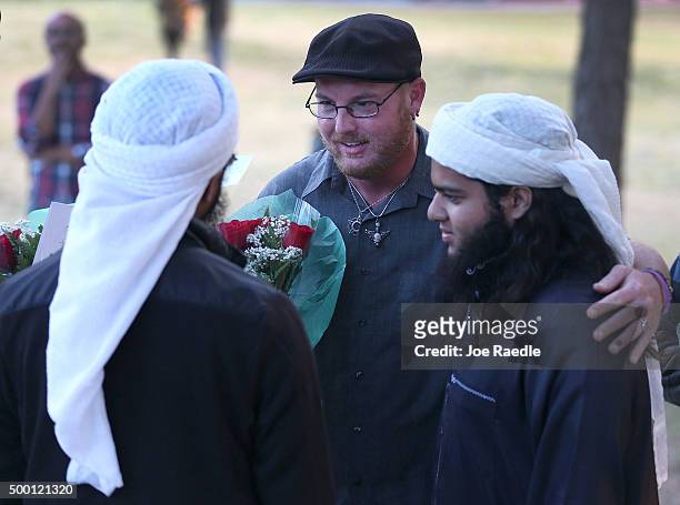 Ryan Reyes speaks with Nizaam Ali and Rahemaan Ali who came to pay their respects during a memorial service at the Santa Fe Dam Recreation Area for...