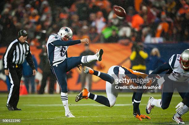 Punter Ryan Allen of the New England Patriots punts while outside linebacker Shaquil Barrett of the Denver Broncos nearly blocks the attremp at...